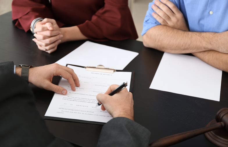 a couple at a desk getting ready to sign paperwork